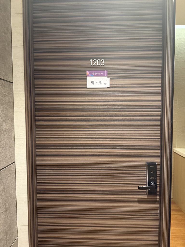 엘리움 산후조리원 스위트룸 1203호 객실 문. 박씨 성의 네임택과 엘리움 산후조리원 로고가 붙어있음